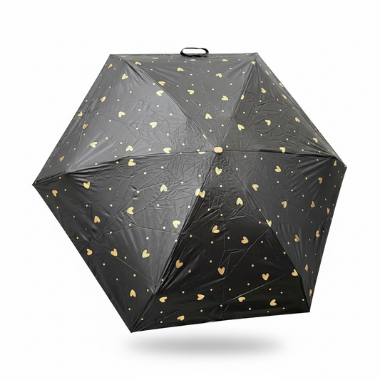Black umbrella with gold heart patterns on a white background