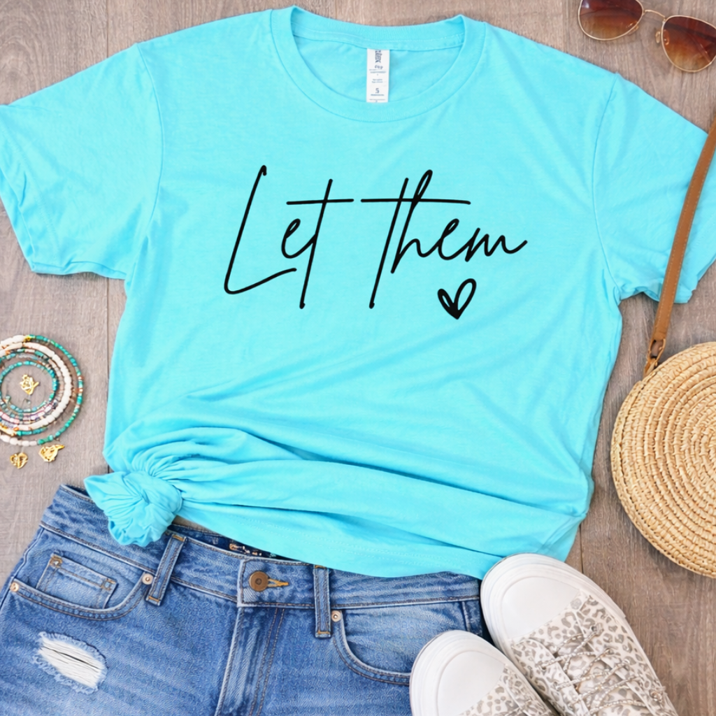 Aqua blue Let Them graphic tee styled with distressed denim shorts and casual sneakers flat lay outfit