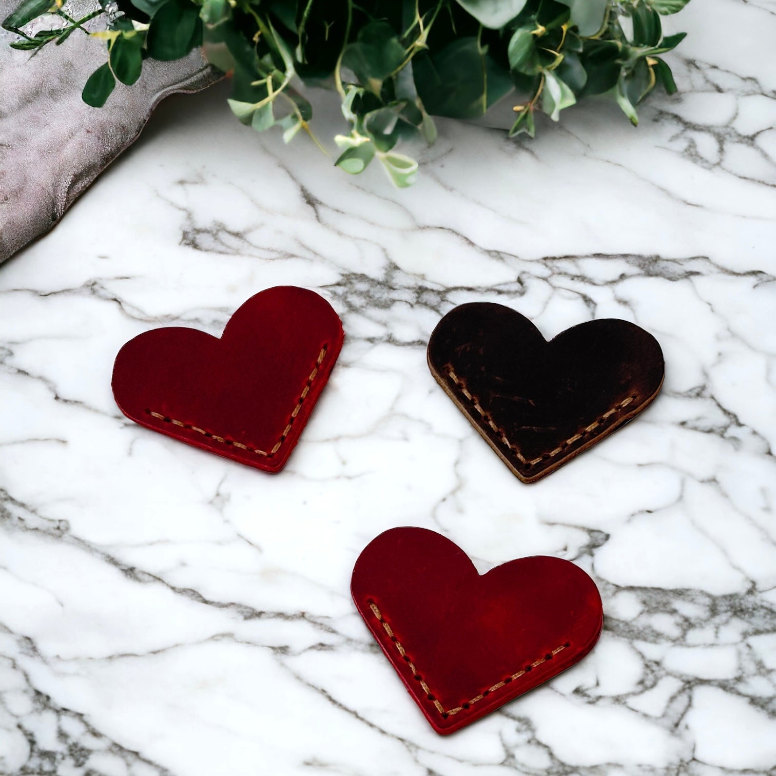 Stitched heart shaped leather bookmark for corner of pages in red and brown. 