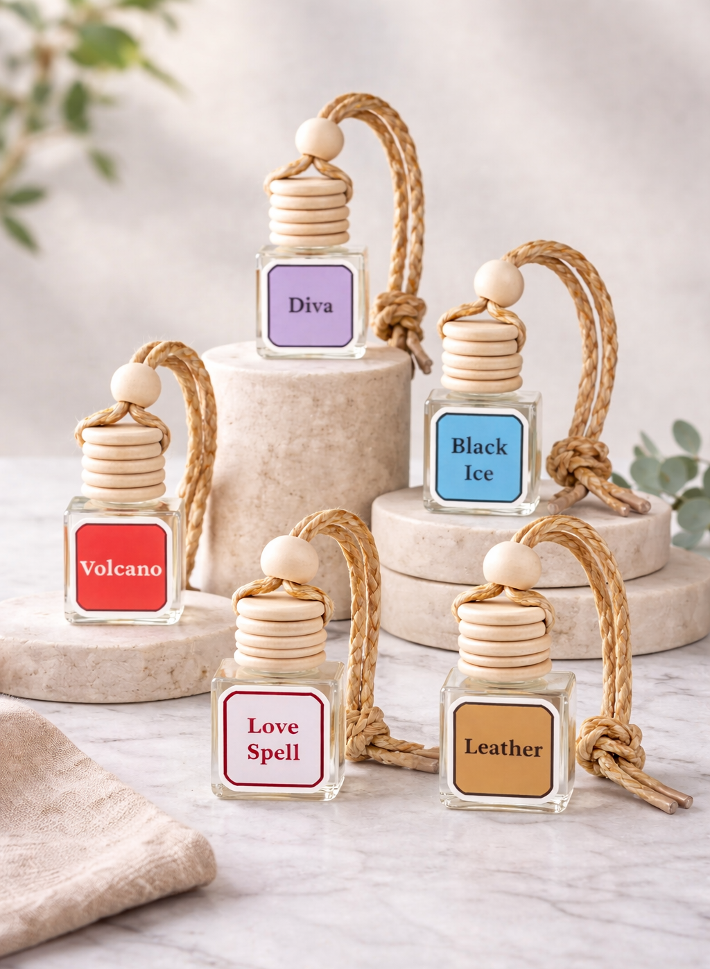 8ml glass hanging scent diffuser with wooden lid and rope, styled on neutral risers with multiple fragrance options