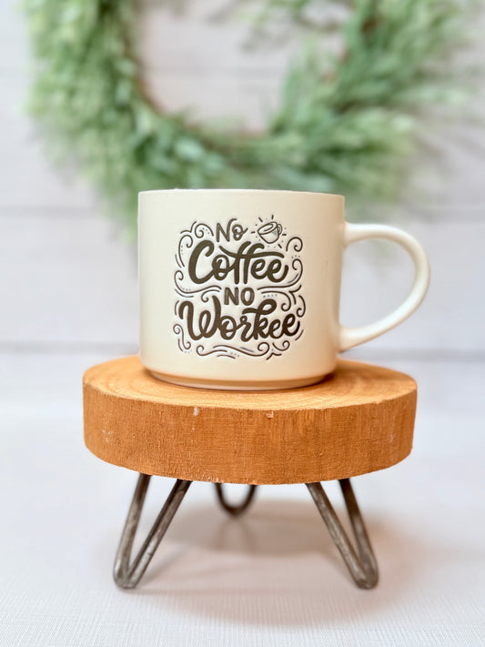 No coffee no workee coffee mug with playful typography styled on a wooden stool with greenery background